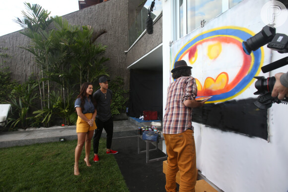 Neymar e Fernanda Souza observam o grafiteiro Kobra