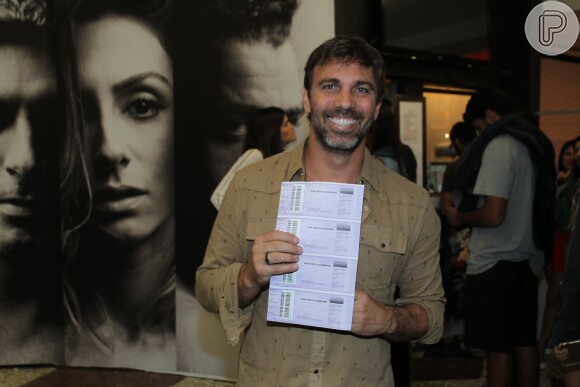 Marcelo Faria posa para as fotos exibindo os ingressos do espetáculo 'Por Isso Fui Embora'