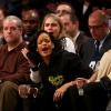 Rihanna e Cara Delevingne riem durante partida de basquete