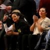 Rihanna observa jogo de basquete, enquanto a amiga aplaude