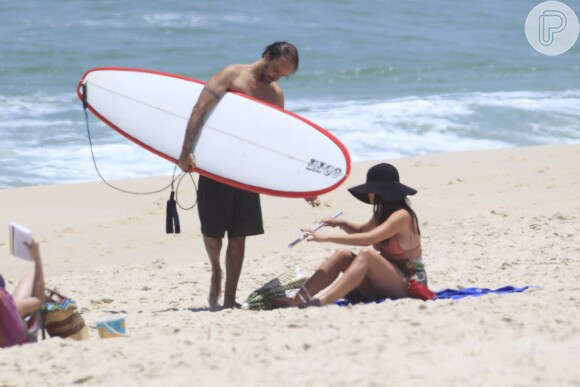 Alinne Moraes, grávida de cinco meses, pega um solzinho enquanto o namorado, Mauro Lima surfa