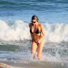 Fernanda Lima sai do mar e exibe a barriga sarada de biquíni