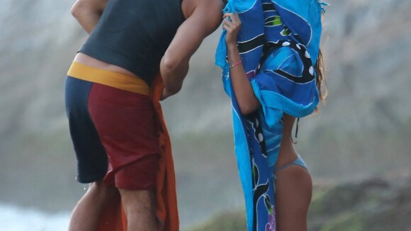 Cauã Reymond e Mariana Goldfarb fazem cabaninha para esconder beijo em praia