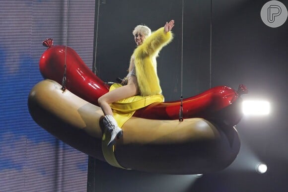 Miley Cyrus voa em cima de uma salsicha gigante na Bangerz Tour