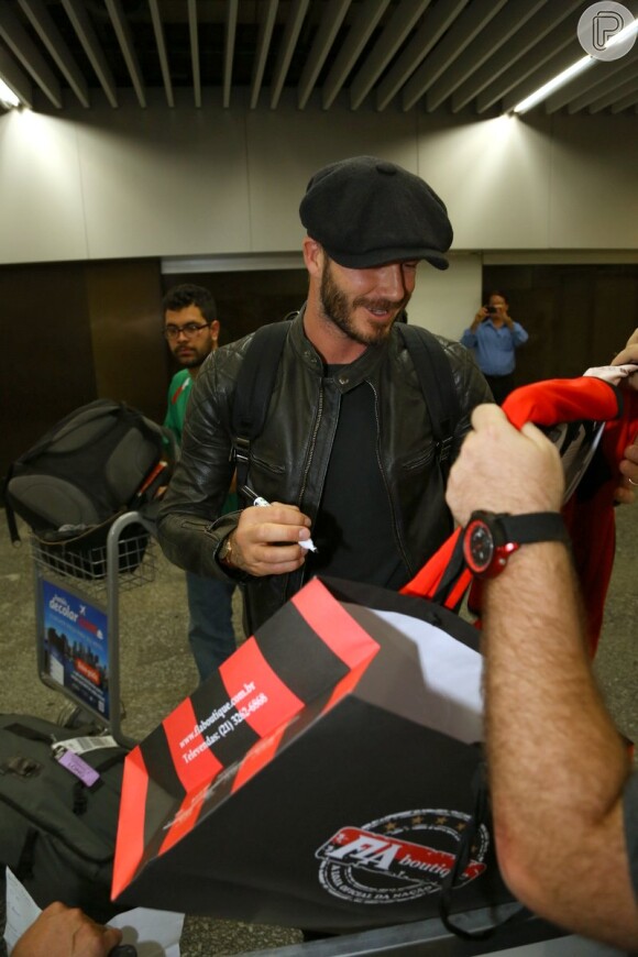 David Beckham autografa camisa do Flamengo para fã em aeroporto do Rio