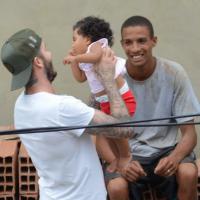 David Beckham posa com fãs e pega bebê no colo em comunidade do Vidigal, no RJ