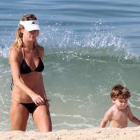 De biquíni, Letícia Birkheuer curte praia carioca com o filho de 2 anos