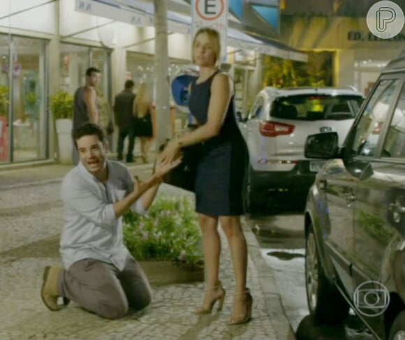 Felipe (Thiago Mendonça) faz uma cena e de joelhos esbraveja que ama Silvia (Bianca Rinaldi), no meio da rua, em cena da novela 'Em Família'