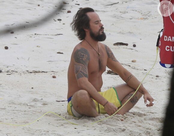 Paulinho Vilhena medita antes de surfar na Prainha, Zona Oeste do Rio de Janeiro, em 25 de abril de 2014