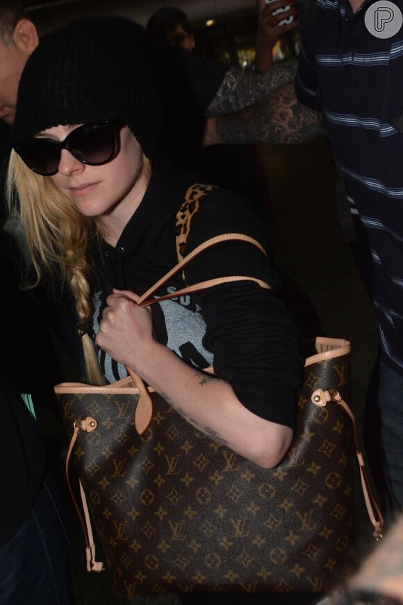Avril Lavigne desembarca com touca e óculos escuros no aeroporto de Guarulhos, em São Paulo, em 28 de abril de 2014