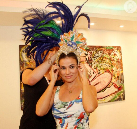 Laryssa Dias experimenta parte da fantasia do Carnaval durante visita ao barracão da Grande Rio, na zona portuária do Rio de Janeiro, em 24 de janeiro de 2013