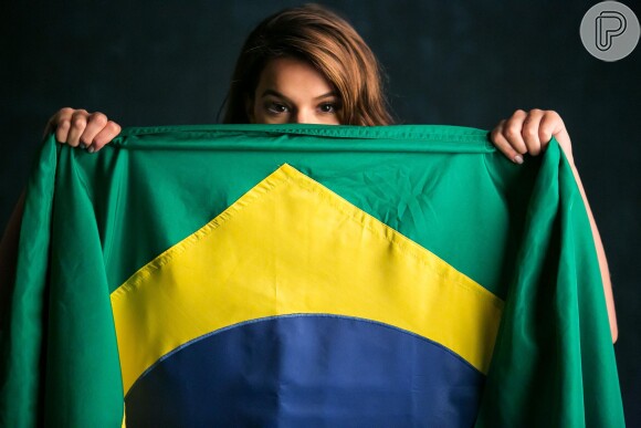 Clicada por J.R. Duran, a campanha traz Bruna e Gabriel posando com a bandeira do Brasil