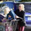Naomi Watts ajuda o filho Alexander, de 5 anos, a subir no carrinho de compras