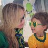 A apresentadora posa ao lado do filho, Arthur, em clima de Copa do Mundo e exibe o lenço com estampa da bandeira do Brasil para combinar com a camisa verde escolhida para torcer pela Seleção nesta quinta-feira, 12 de junho de 2014