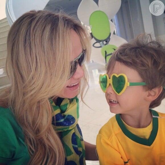 A apresentadora posa ao lado do filho, Arthur, em clima de Copa do Mundo e exibe o lenço com estampa da bandeira do Brasil para combinar com a camisa verde escolhida para torcer pela Seleção nesta quinta-feira, 12 de junho de 2014