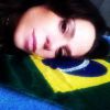 A atriz Vanessa Gerbelli posa deitada num trevesseirinho com a bandeira do Brasil: 'Terra boa e gostosa'