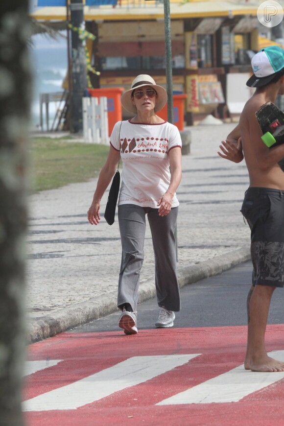 Com óculos e chapéu, Christiane Torloni caminha na orla carioca