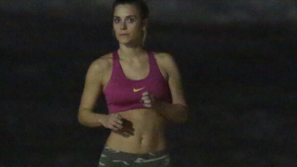 Carolina Dieckmann mostra barriga sarada durante treino em praia do Rio