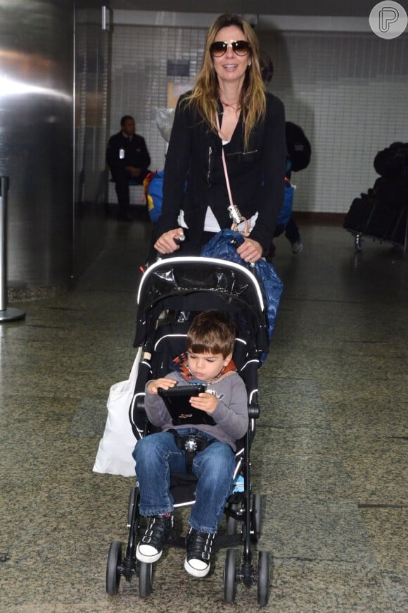 Luciana Gimenez desembarca com o filho Lorenzo Gabriel no aeroporto internacional de São Paulo após curtir aniversário de Mick Jagger nos Estados Unidos (28 de julho de 2014)