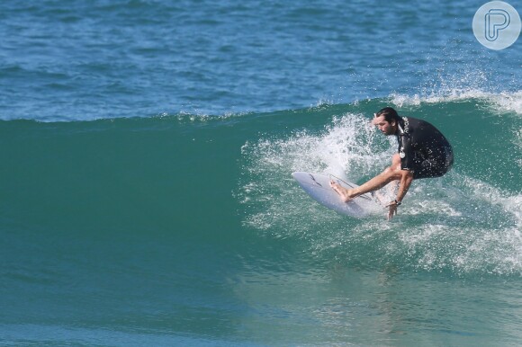 Vladimir Brichta faz manobras sobre ondas em manhã de sol. Ator surfou em uma praia no Recreio dos Bandeirantes, Zona Oeste do Rio de Janeiro