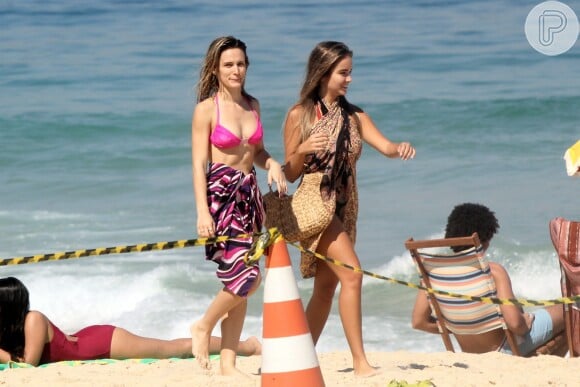 Bianca Bin observa a presença de paparazzi na praia, mas não se incomoda