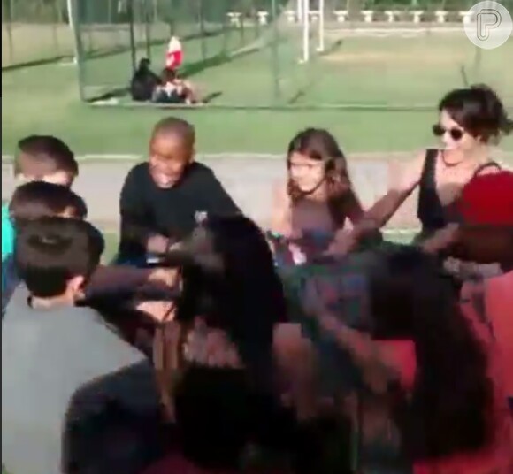 Juliana Paes brinca com um grupo de crianças no carrossel