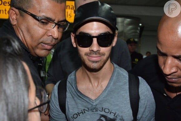 Joe Jonas, ex-Jonas Brothers, sorri ao se deparar com fotógrafos