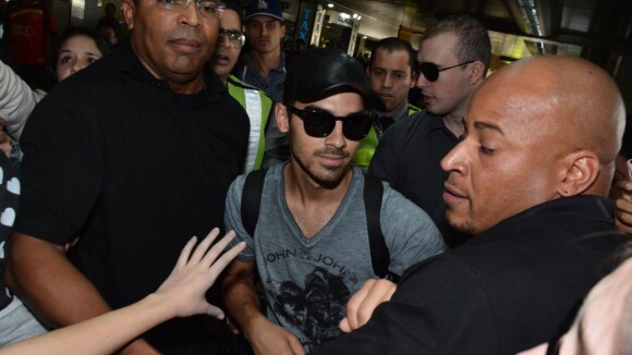 Com assédio de fãs, Joe Jonas é escoltado por seguranças ao chegar a São Paulo