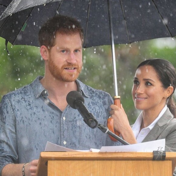 Ainda na viagem à Austrália, Meghan Markle chamou atenção ao segurar guarda-chuva para o marido, príncipe Harry