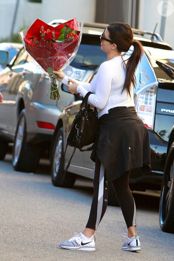 Kim Kardashian chega à academia em Los Angeles, na Califórnia, segurando um enorme buquê de rosas vermelhas