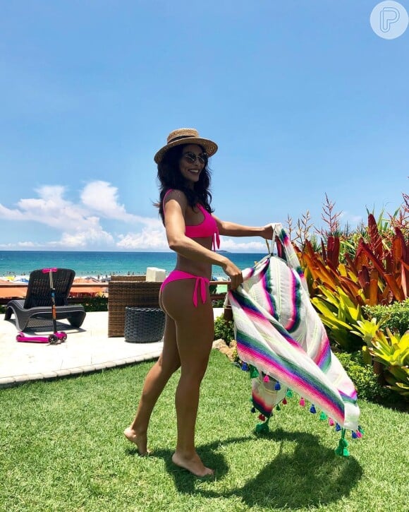 Para dar ainda mais cor ao beachwear, Juliana Paes usou uma canga colorida junto com um biquíni rosa neon