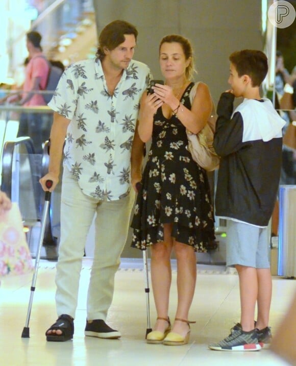 De muletas e bota ortopédica, Vladimir Brichta passeou em shopping com a mulher, Adriana Esteves, e o filho do casal, Vicente