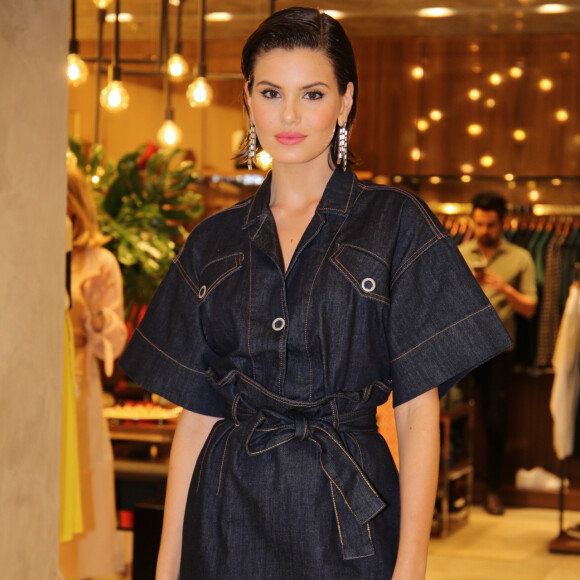 Camila Queiroz usou blusa de botão e minissaia jeans em evento da Forum