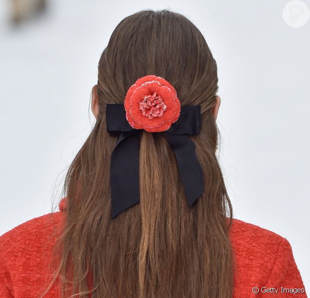 Laço de fita e flor da mesma cor que a roupa estilizavam os looks das modelos da Chanel