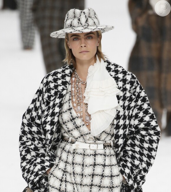 O chapéu de tweed preto e branco também estilizou o cabelo de tops como Cara Delevingne no desfile da Chanel