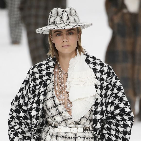 O chapéu de tweed preto e branco também estilizou o cabelo de tops como Cara Delevingne no desfile da Chanel