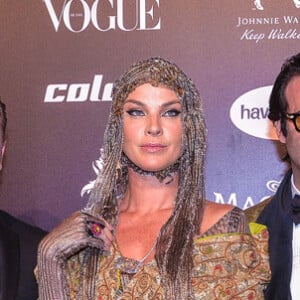Baile da Vogue: Leticia Birkheuer usou acessório de cabeça, capa e vestido em tons de dpurado em um mix de tenxturas