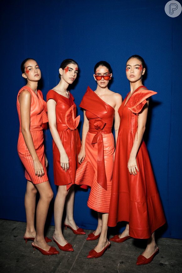 Mangas estruturadas e pegada retrô nos vestidos de couro de Patrícia Motta com color blocking de laranja e vermelho