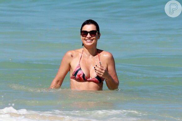 De biquíni, Flávia Alessandra se refrescou na praia da Barra da Tijuca, no Rio de Janeiro