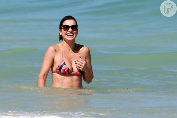 Flávia Alessandra se refrescou no mar em dia na praia