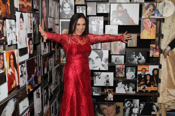 Regina Duarte posa mostrando o vestido vermelho que usou para a abertura de sua exposição