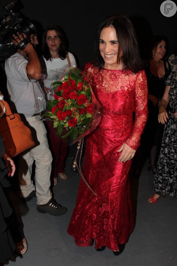 Regina Duarte vibra com o buquê de rosas vermelhas que ganhou durante o abertura da exposição