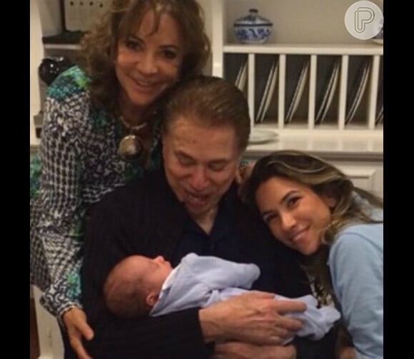O vovô babão Silvio Santos posou segurando o netinho Pedro no colo ao lado da filha Patricia Abravanel, e da mulher, Íris Abravanel