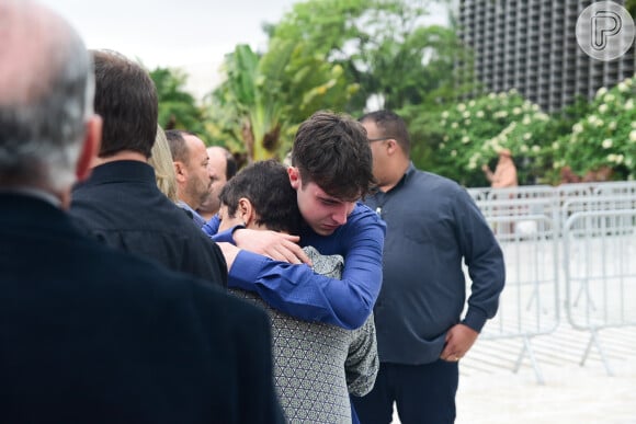 Filho de Gugu Liberato ganha abraço apertado da assessora Esther Rocha, na entrada da Alesp, ao chegar em velório do pai, em São Paulo