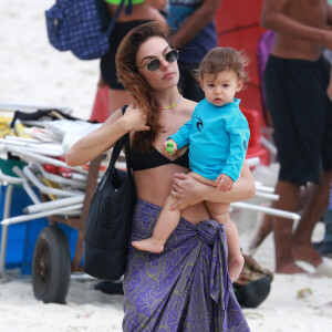 Isis Valverde, com o filho, Rael, no colo, deixa praia com saída de praia roxa