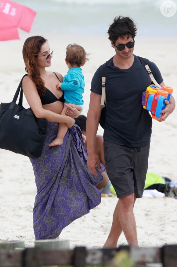 Isis Valverde leva o filho, Rael, no colo após dia de praia em família