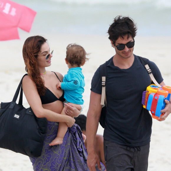 Isis Valverde leva o filho, Rael, no colo após dia de praia em família