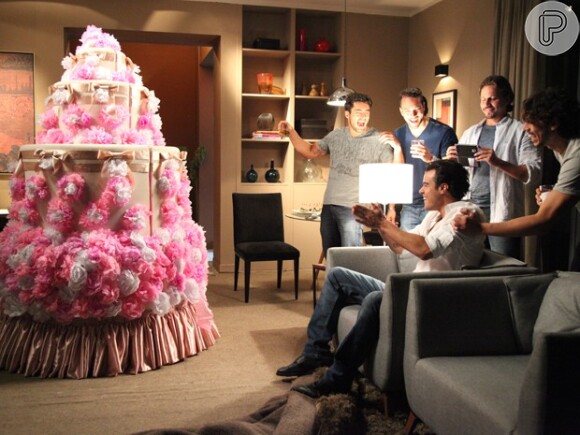 Sem saber que a surpresa foi enviada por Téo (Paulo Betti), Enrico (Joaquim Lopes) se anima diante do bolo gigante, em 'Império'
