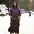 Saia midi na moda: modelo vinílico faz dupla com blusa de couro em look monocromático