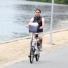 Com look preto e branco, Glenda Kozlowski anda de bicicleta no Rio de Janeiro